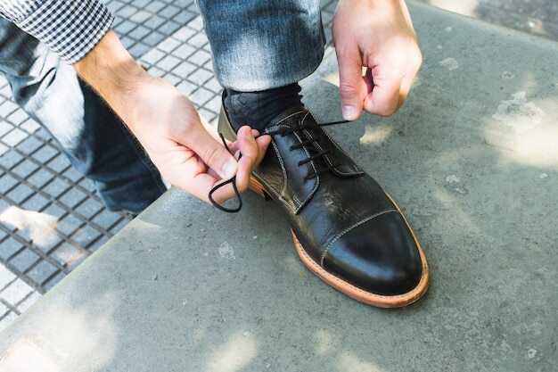 An overhead view of a man tying his shoelace