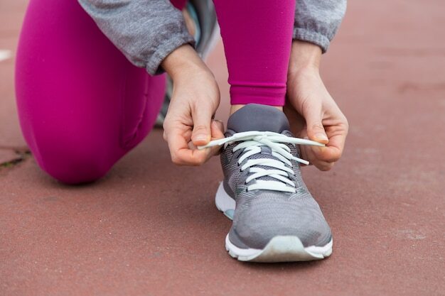 Close-up of runner tying lace of sport shoe