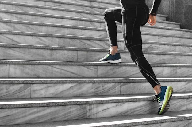 Side view of man in athletic wear exercising on stairs outdoors