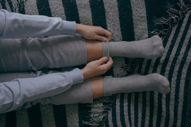 Top view of a young female putting on some socks on a cold day to spend at home Cozy Home Concept.
